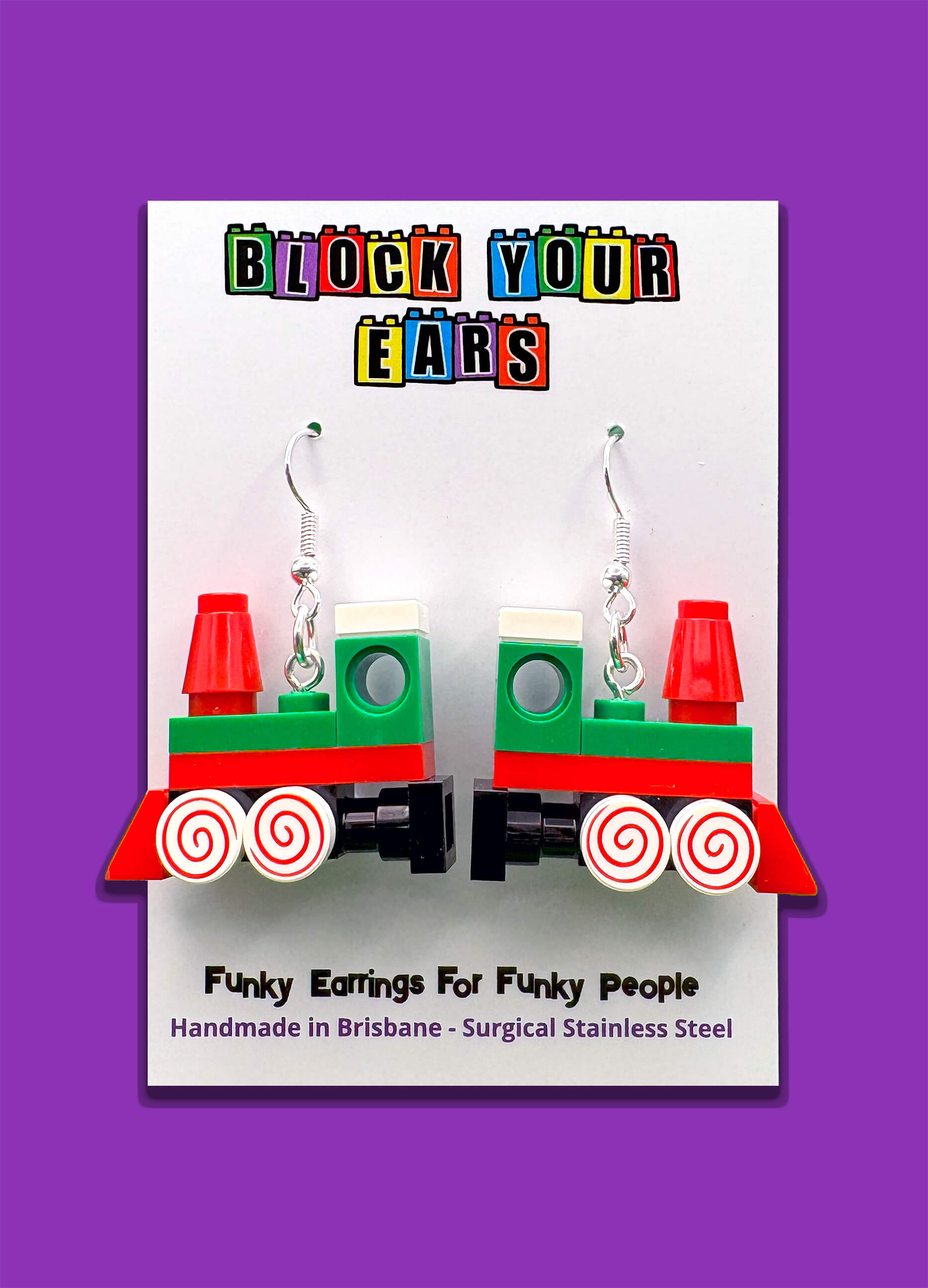 Handmade Christmas Train LEGO earrings displayed on backing card with purple background