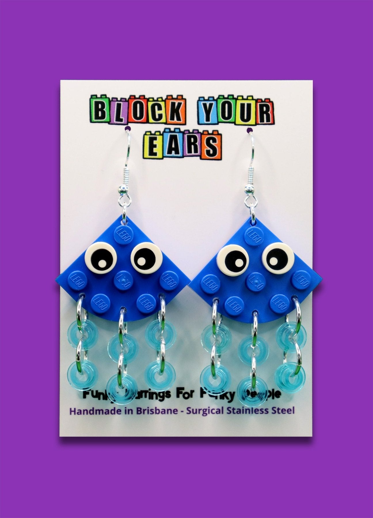 Quirky blue LEGO earrings-Jellyfish with transparent blue tentacles and cartoon eyes - fun statement earrings on display card