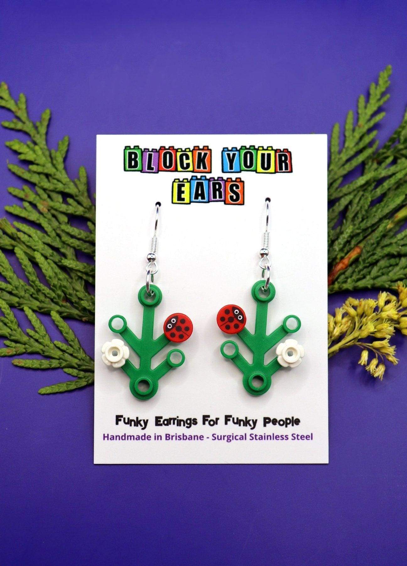 Ladybird, ladybug, lady beetle on LEGO plant-Cute and quirky earrings on display card -Blue background with leaves