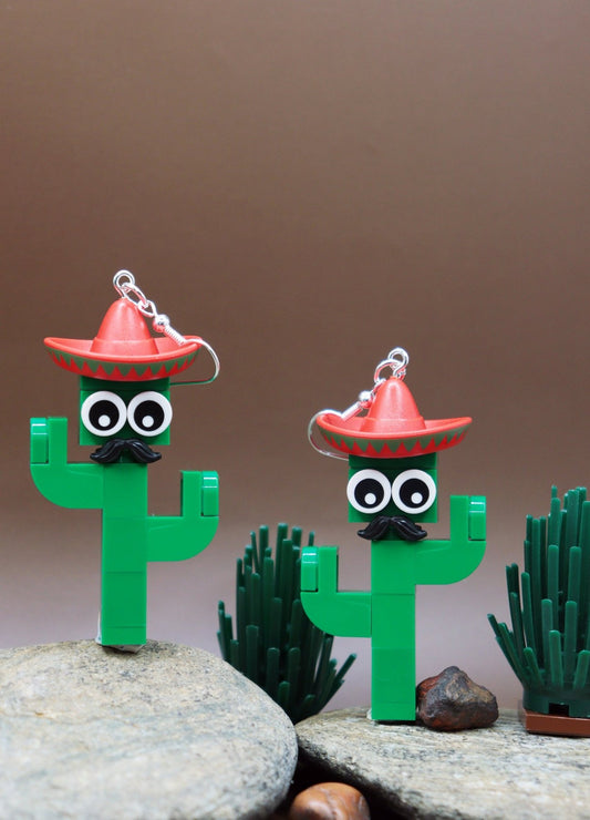 Moustachioed Amigos green LEGO cactus earrings, red sombreros, cartoon eyes, and black moustaches – novelty earrings-darker