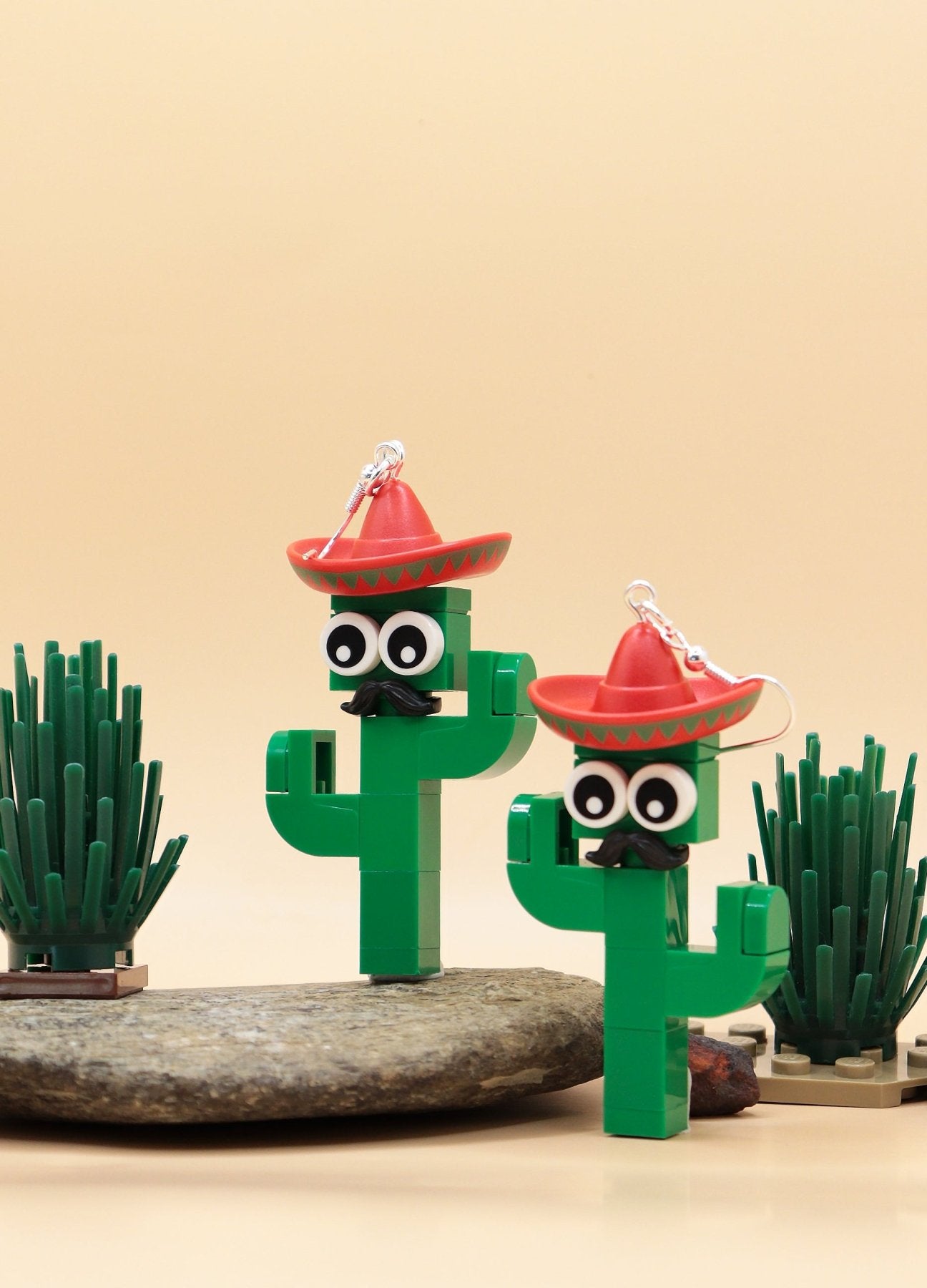 Moustachioed Amigos green LEGO cactus earrings, red sombreros, cartoon eyes, and black moustaches – novelty earrings-on rock