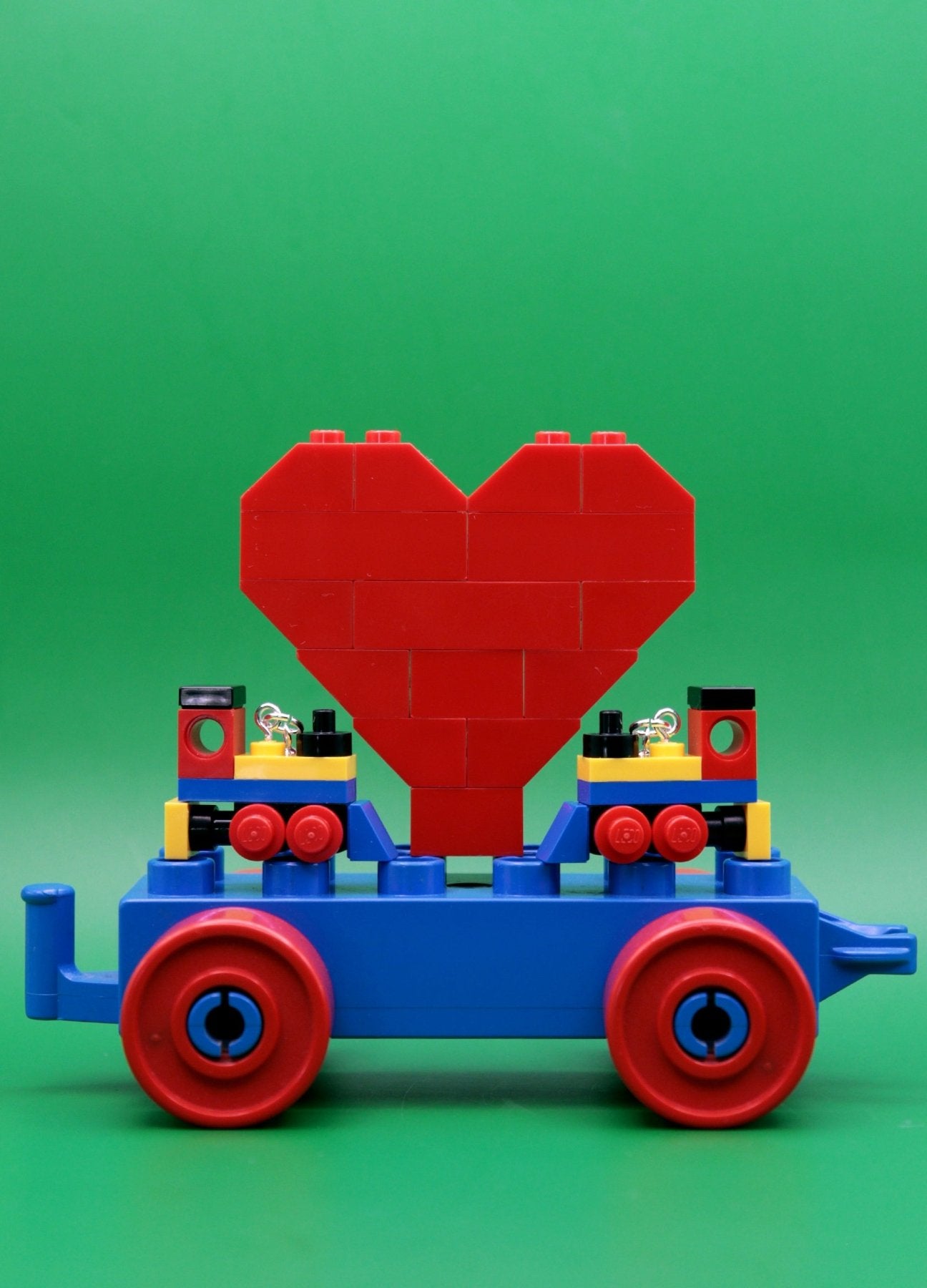 Miniature train earrings made from LEGO-Cute novelty earrings -Yellow/Blue/Red-heart-green background