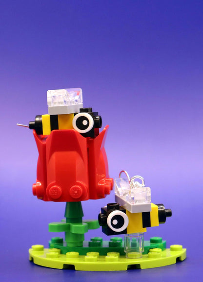 Close up of bee earrings on a red flower - handmade in Australia with LEGO bricks