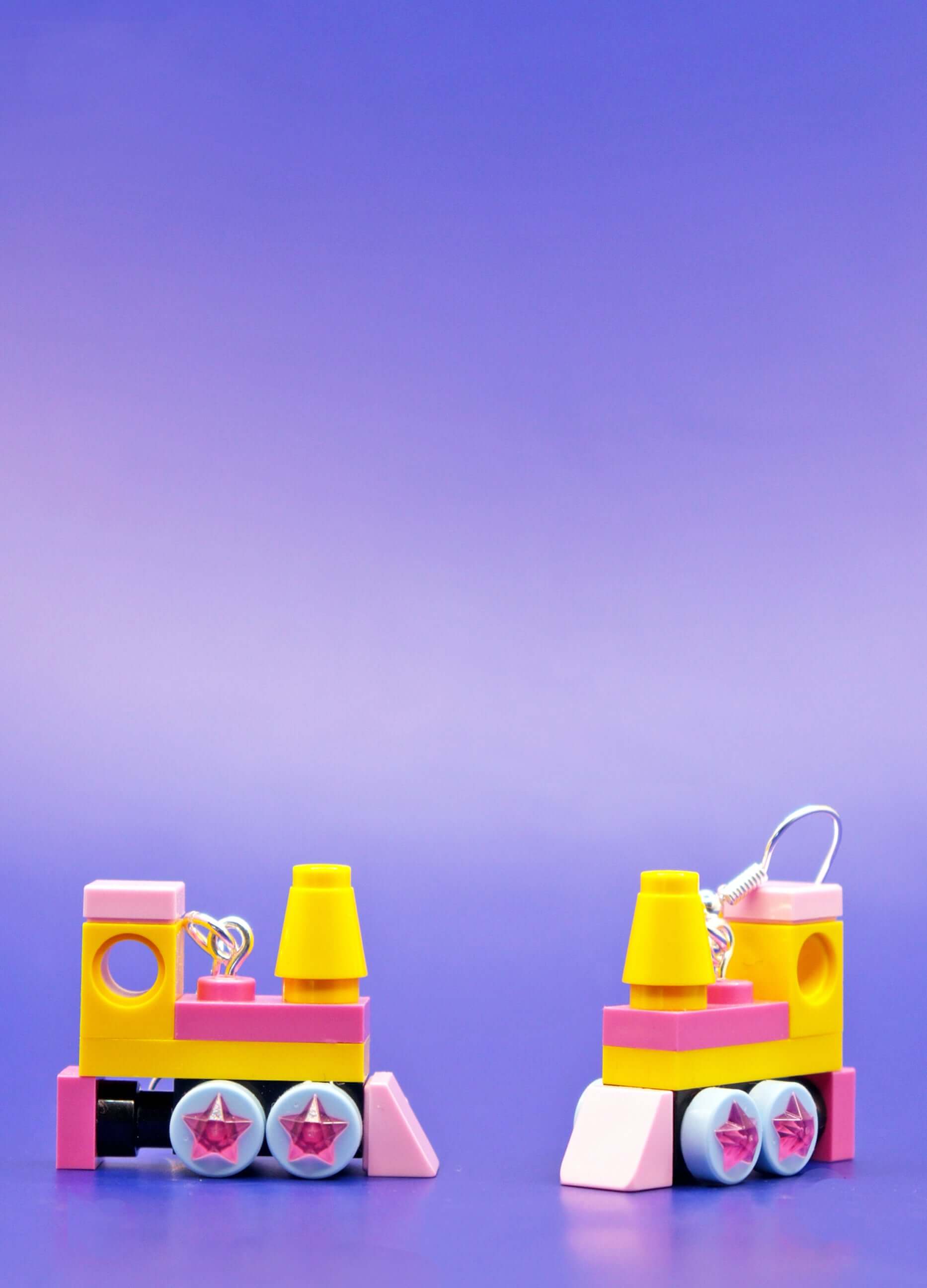 Close up and side view of yellow and pink handmade LEGO steam train dangle earrings